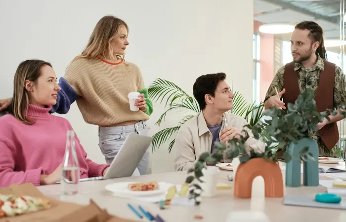 Team collaborating around laptops in an office, City Service Network Hub helps businesses list and manage local services